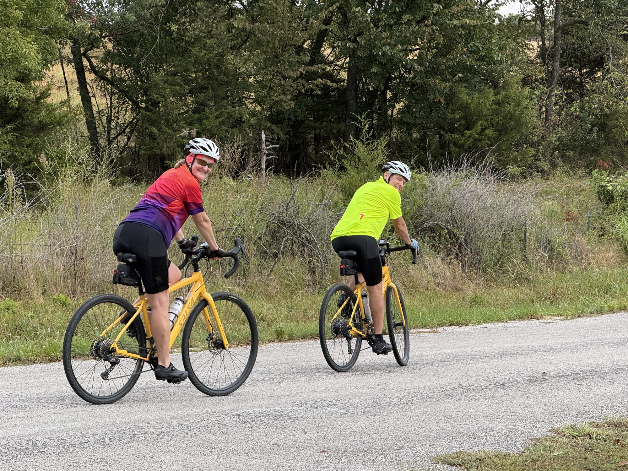 Country Miler 2026 — two riders looking back from yellow bikes on the road